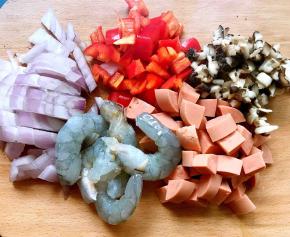 发酵面团时备好馅料，将洋葱、红椒、火腿肠、香菇洗净切成丁，虾洗净去皮抽出虾线洗净备用