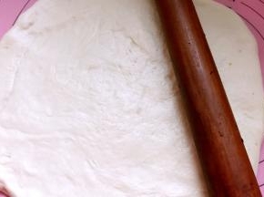 用擀面杖擀成饼皮，比披萨盘大一圈即可