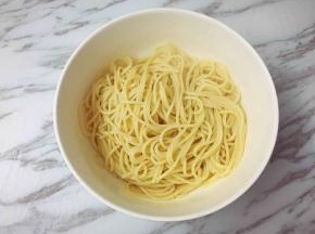 面条煮好后捞起沥干水，装入大碗里，加入一小勺橄榄油拌匀，防止黏连。