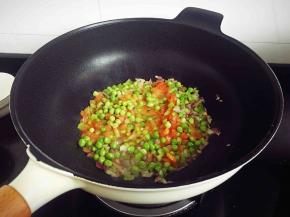 依次加入番茄丁、青豆粒，翻炒均匀。