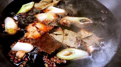 将大葱段、姜块、老抽、生抽、豆瓣酱、盐、白酒、冰糖和所有香料一同放入锅中