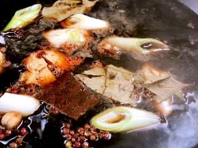 将大葱段、姜块、老抽、生抽、豆瓣酱、盐、白酒、冰糖和所有香料一同放入锅中