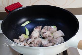炒锅中放入适量的植物油，爆香葱姜后，放入焯水后的羊排翻炒