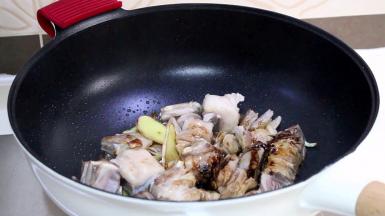 炒至羊小排表面略有焦色时，依次放入米酒、生抽、老抽，羊排翻炒均匀