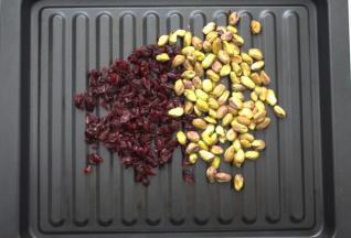 蔓越莓干，开心果放在烤盘中放入烤箱里，上下火70度进行保温