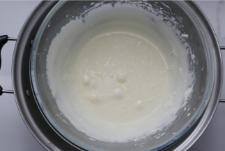 再把糖浆慢慢倒入蛋白霜里，注意不要倒在打蛋器上，再用电动打蛋器高速打至均匀，打到有感觉到阻力时就可以（备注：这一步要多打一会，这样做出来的牛轧糖才不会粘牙也有嚼劲一点）