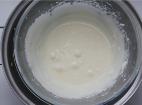 再把糖浆慢慢倒入蛋白霜里，注意不要倒在打蛋器上，再用电动打蛋器高速打至均匀，打到有感觉到阻力时就可以（备注：这一步要多打一会，这样做出来的牛轧糖才不会粘牙也有嚼劲一点）