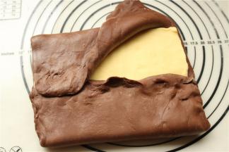 冻过的面团，和黄油保持一个硬度，擀大，把黄油片包在里面，边缘捏紧。