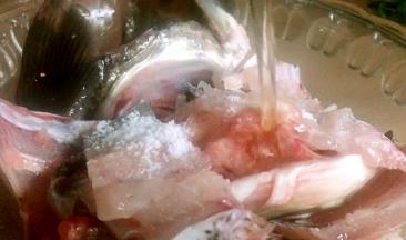 鱼骨剁成块，同鱼头一起放入容器内，加入盐和料酒拌匀腌制入味