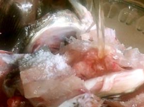 鱼骨剁成块，同鱼头一起放入容器内，加入盐和料酒拌匀腌制入味