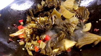 放入泡椒碎、酸菜炒至酸菜出浓香味