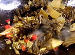 放入泡椒碎、酸菜炒至酸菜出浓香味