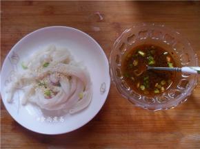 河粉过一下凉水、沥干倒入碗里，撒些白芝麻，用另一碗盛起面豉酱、酱油、香辣酱、小葱梗、香油，拌匀放在一旁待用