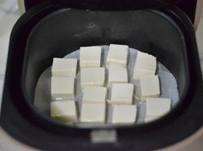豆腐切块放入炸锅，豆腐上刷一层薄薄的油，210度25分钟左右，中途翻面