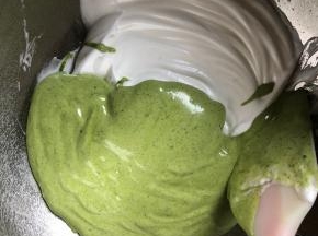 将蛋黄糊倒入蛋白中，用翻拌和切拌的手法拌匀