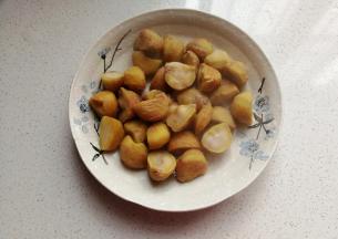 再趁热剥去毛壳，然后把栗子掰开，我买的栗子个头大，掰开容易入味；