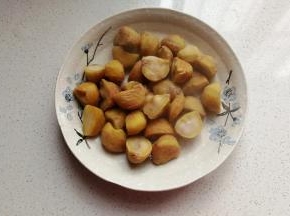 再趁热剥去毛壳，然后把栗子掰开，我买的栗子个头大，掰开容易入味；