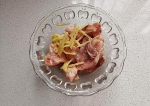 然后把鸡翅从中间斩开，加入少许姜丝，盐，料酒拌均匀腌制20分钟；