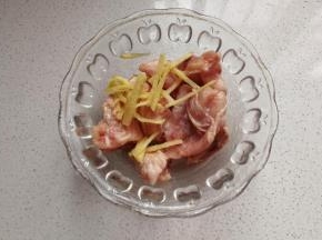 然后把鸡翅从中间斩开，加入少许姜丝，盐，料酒拌均匀腌制20分钟；