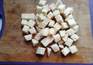 将剩土司或剩面包切成小方丁；