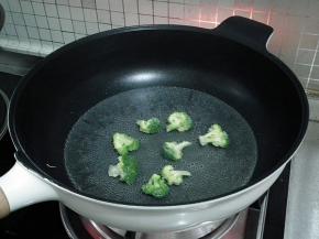 锅中注入水，加入一点盐和几滴油烧开后将西兰花焯水，冲凉后沥干水分。