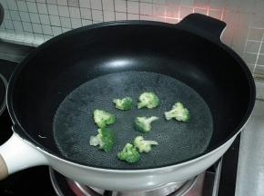 锅中注入水，加入一点盐和几滴油烧开后将西兰花焯水，冲凉后沥干水分。
