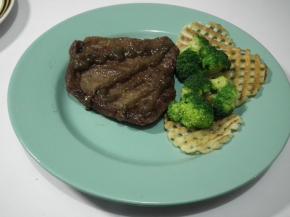 将牛排放入配菜的盘中，挤上黑胡椒酱即可。