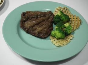 将牛排放入配菜的盘中，挤上黑胡椒酱即可。