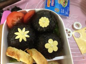 然后将小花放入紫菜饭团上，放入糖珠