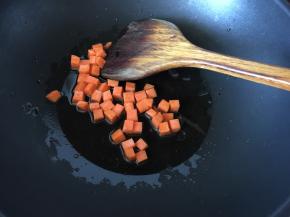 锅里热油后放入切粒的胡萝卜炒香