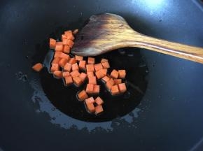 锅里热油后放入切粒的胡萝卜炒香