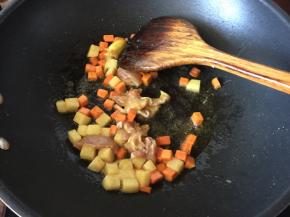 然后放入切粒的土豆和去骨切小块的鸡肉炒香