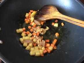 然后放入切粒的土豆和去骨切小块的鸡肉炒香