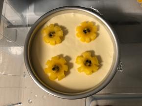 凝固的慕斯放上菠萝小花片，中间放入一点百香果果肉