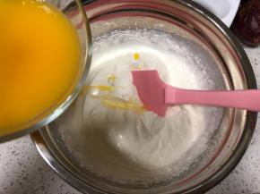 分两次倒入百香果吉利丁溶液，每一次都用刮刀翻拌均匀完全融合