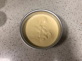 翻拌均匀的蛋带糊倒入6寸活底模具中，轻轻在桌上磕几下震出大气泡