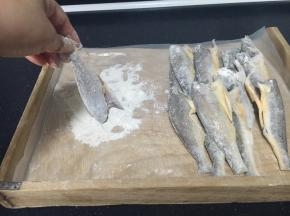 小黄花鱼的两面蘸上面粉。