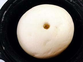 取一个小碗倒入发酵粉加入适量白糖温水搅拌待激发后加入面粉里，再加入温水边拌边倒，先拌成絮状后手揉光滑面团，将面团盖上湿润的屉布，温暖处进行发酵，图上是发好的状态。