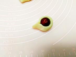 将剂子搓成小条儿，取一枚小枣，将搓好的面条围在竖着摆放的小枣外面，捏紧面条的两端，形成一个水滴状的造型。