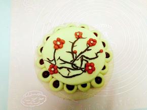 将梅花摆放在花糕的顶盖上