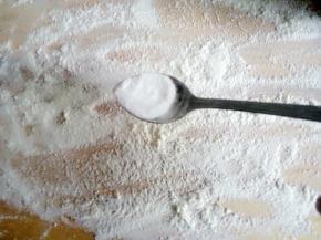 案板上放少许面粉，放小半勺碱面，用擀面杖擀开后和面粉搅匀