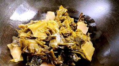 锅置火上不给油，放入酸菜炒香