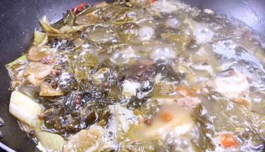 锅内的酸菜鱼骨煮好了，加入盐、胡椒粉和味精拌匀