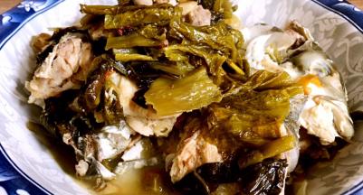 捞出鱼骨和酸菜装入碗内，汤汁留锅内