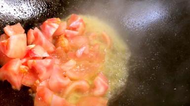 将锅里的热油倒出来，留底油，放入番茄炒熟烂