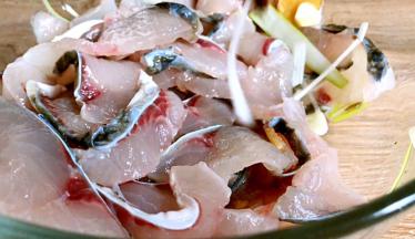 将腌制好的鱼片内的葱、姜、蒜夹出丢弃