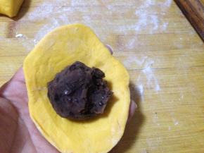 擀成四边薄、中间厚的圆片，加入适量豆馅