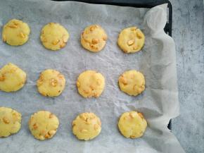 再将拌好的面团分成20克一个的小团子放入铺好油纸的烤盘，用手指按扁