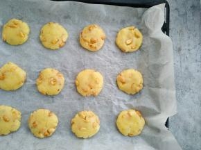 再将拌好的面团分成20克一个的小团子放入铺好油纸的烤盘，用手指按扁