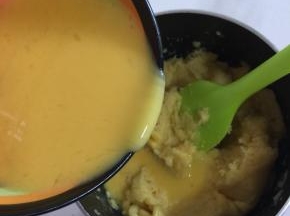 待面团晾至温热不烫手的时候，分几次把搅拌好的蛋液倒进面团中，用硅胶刮刀搅拌。一开始可以多倒一点儿蛋糊，越往后越要少量多次加；材料图中的鸡蛋只出现4个，而实际用了4个半。